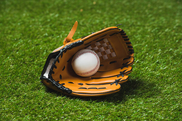 бейсбольная перчатка с мячом на траве
