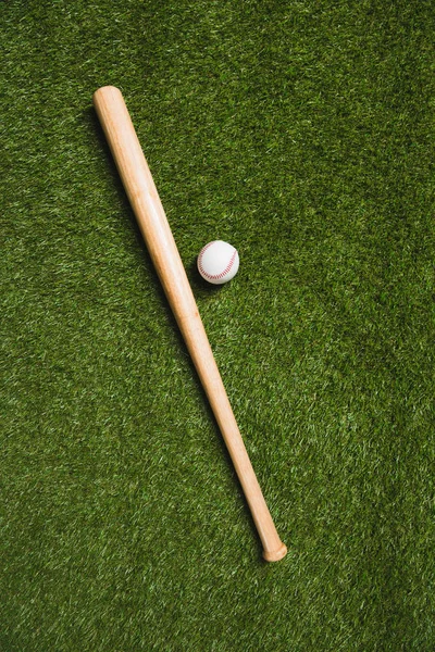 Honkbalknuppel en bal op gras — Stockfoto