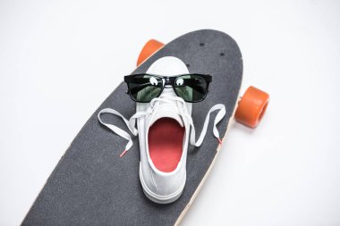 sneaker and sunglasses on skateboard