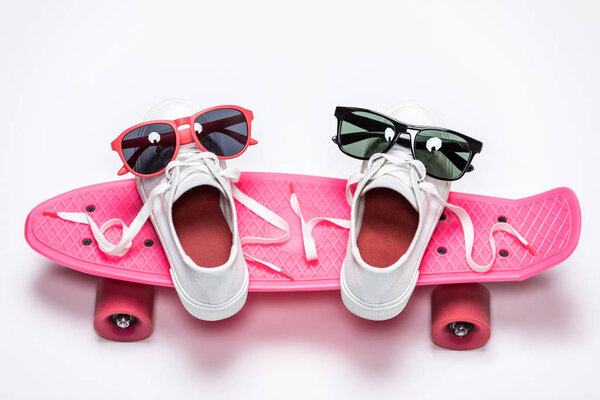 sneakers and sunglasses on skateboard