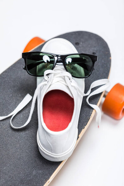sneaker and sunglasses on skateboard