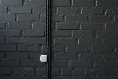 brick wall with switch and wires