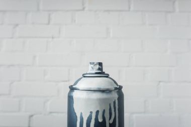 close up view of aerosol paint in can with white brick wall background clipart