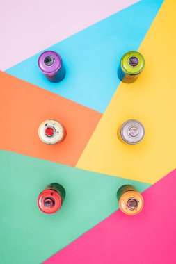 Düzenlenmiş aerosol kutular Paint'te üstten görünüm renkli arka plan üzerinde