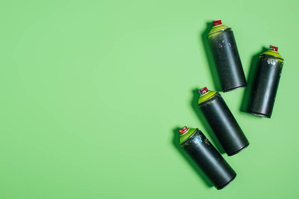 top view of arranged cans with aerosol paint isolated on green