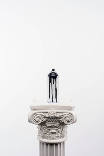 close up view of spray paint in can standing on column isolated on white