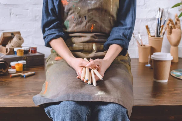 テーブルの上に座って 鉛筆を保持している女性アーティストのトリミングされた画像 — ストック写真
