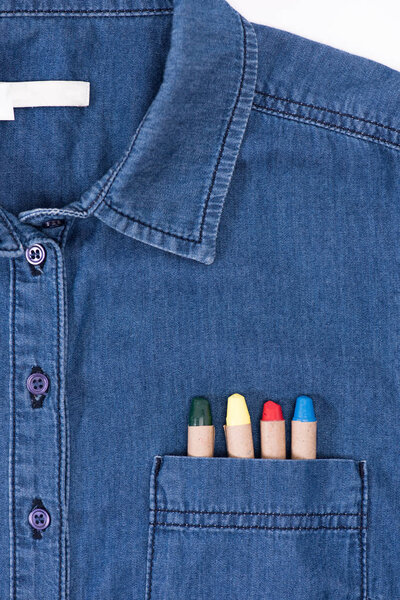 close-up view of stylish denim shirt with colorful pastels in pocket   