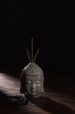 tütsü kafayla Buda heykeli ahşap masa üzerinde sopa