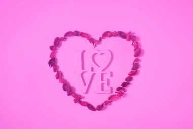 top view of heart from dried fruits with word love isolated on pink clipart