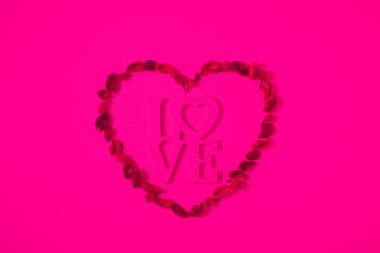 top view of heart from dried fruits with word love isolated on pink clipart