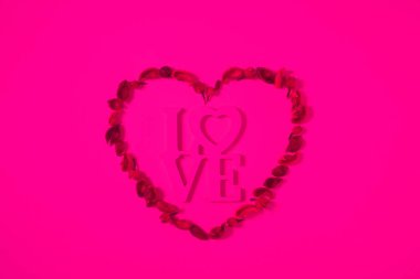 top view of heart from dried fruits with word love isolated on pink clipart