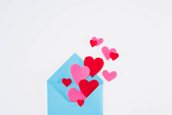 top view of blue envelope with paper hearts isolated on white, valentines day concept