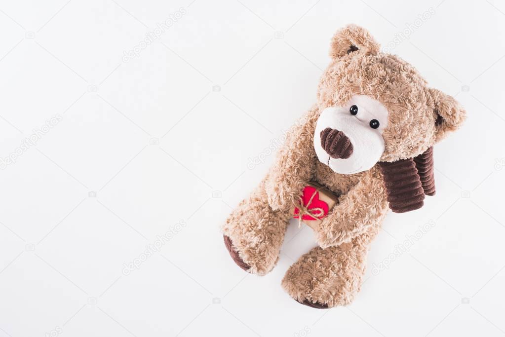 top view of teddy bear with heart shaped gift box isolated on white, valentines day concept