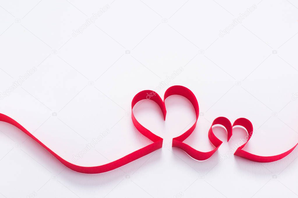 two red hearts from ribbon on white, valentines day concept