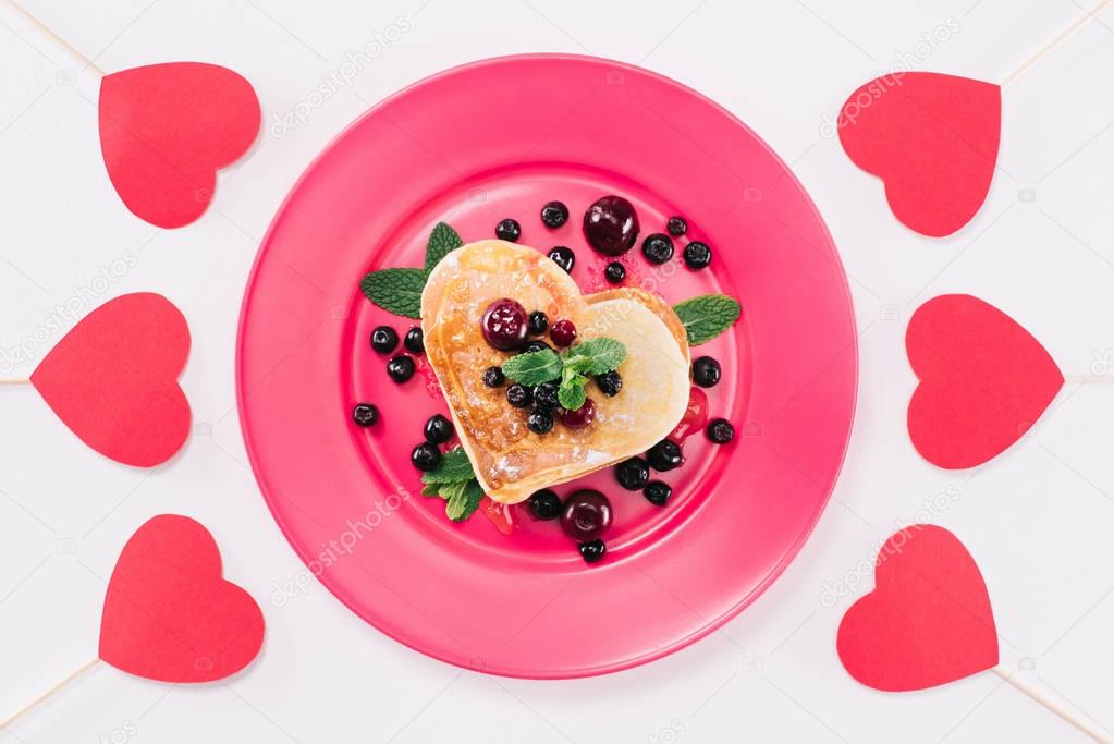 top view of heart shaped pancake with berries isolated on white, valentines day concept