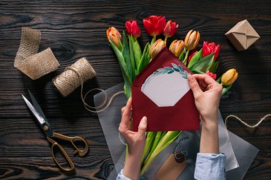 kadının elinde kartpostal ve Lale kağıt üzerinde ahşap masa üstü ambalaj içinde kırpılmış atış