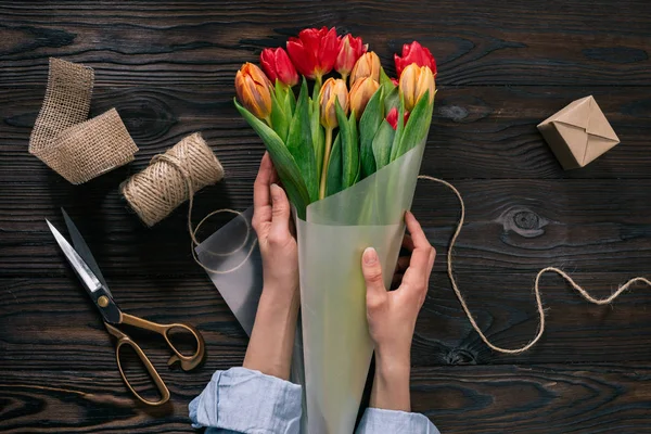 Partial View Woman Wrapping Bouquet Tulips Wrapping Paper Wooden Tabletop — Stock Photo, Image