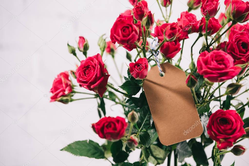 close up view of beautiful bouquet of roses with blank card