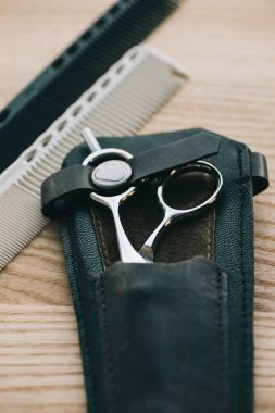 makas ve tarak saç şekillendirme için ahşap masa üzerinde görünümünü kapat