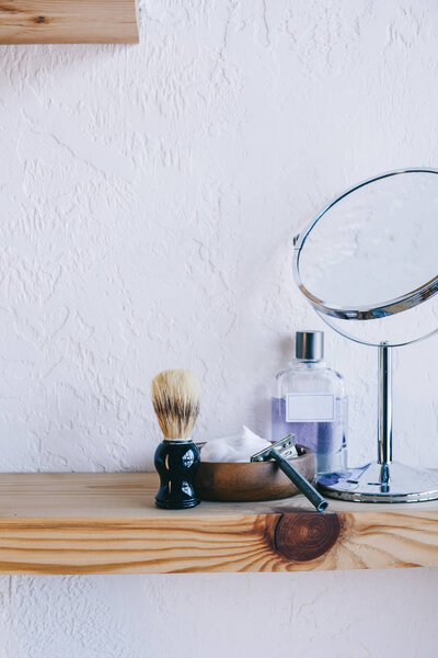 close up view of arranged barber equipment for shaving on wooden shelf