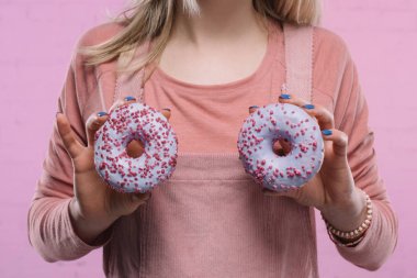 cropped shot of woman covering breast with glazed doughnuts clipart