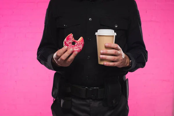 手持被咬的甜甜圈和纸杯咖啡的警察的被裁剪的射击 — 图库照片