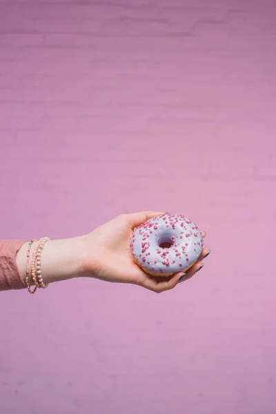 Ritagliato Colpo Donna Che Tiene Mano Ciambella Smaltata Davanti Muro — Foto Stock