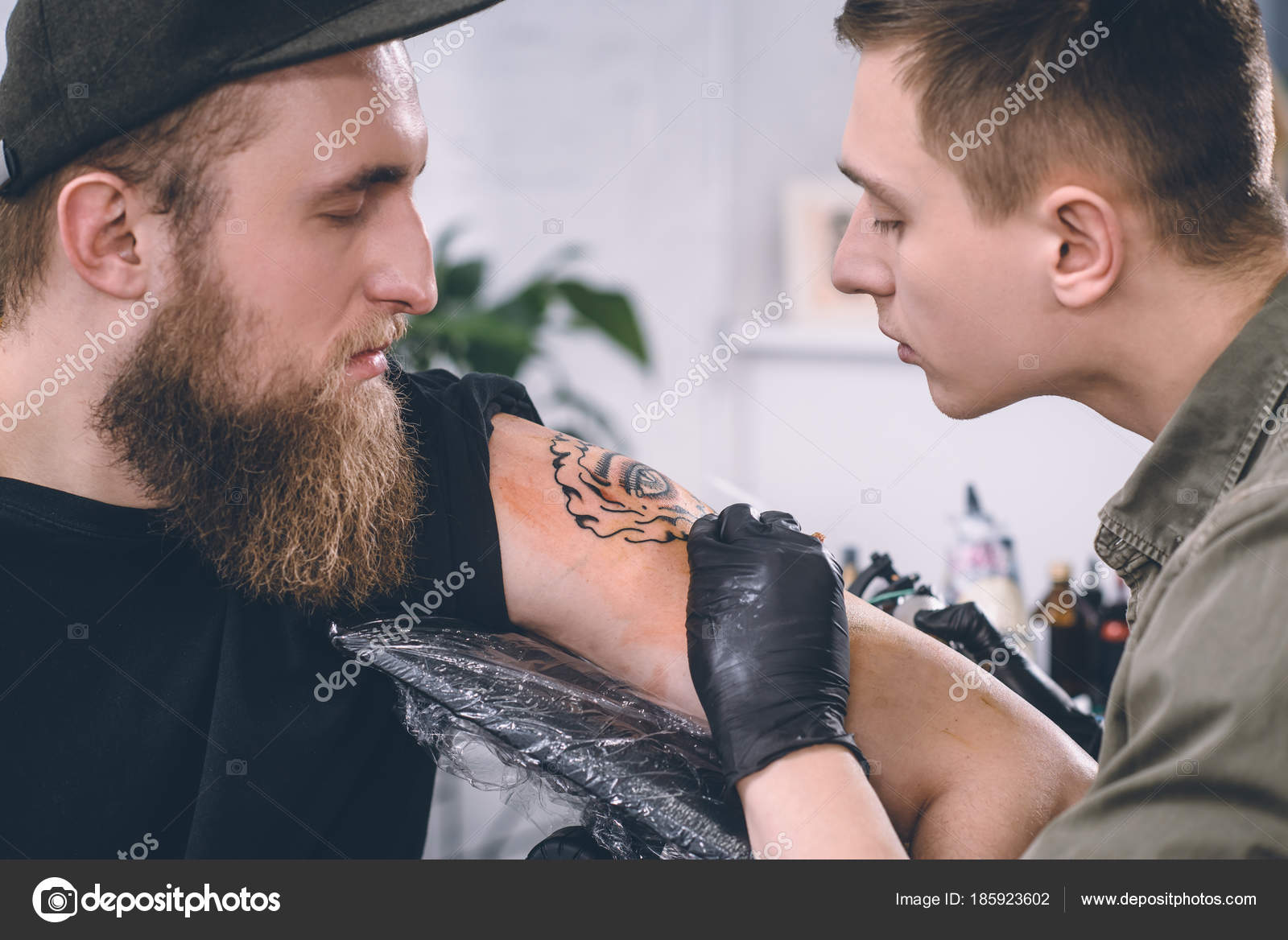 Artista tatuaje haciendo barba en barbería con tijeras. - Foto de stock
