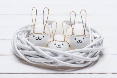 easter chicken eggs with smileys and bunny ears in nest clipart