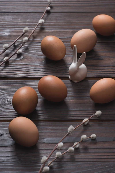 鶏の卵と木製のテーブルにイースターのウサギ — ストック写真