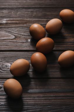 raw chiken eggs on wooden table clipart