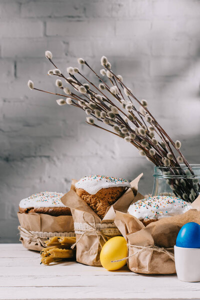 easter bread, painted chicken eggs and candles on wooden table