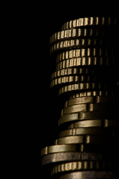 close up view of pile of coins isolated on black