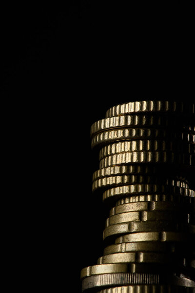 close up view of pile of coins isolated on black