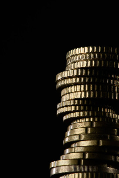 close up view of pile of coins isolated on black