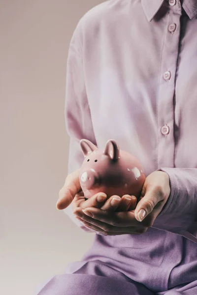 Visão Parcial Mulher Segurando Banco Piggy Rosa Mãos Isoladas Lilás — Fotografia de Stock