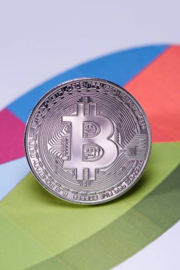Close up view of silver bitcoin on colorful diagram clipart