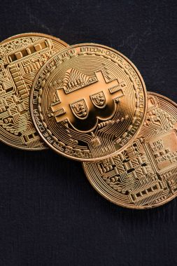Close up view of golden bitcoins isolated on black clipart