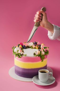 kırpılan atış olan bıçak, fincan kahve ve süslü pasta pembe üzerinde izole kadın