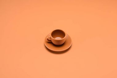 close up view of empty cup on saucer isolated on peach clipart