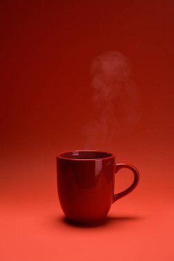 close up view of red cup of coffee isolated on red clipart