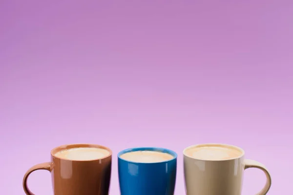 关闭视图的安排五颜六色的咖啡杯 孤立的紫色 — 图库照片