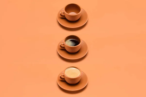 在桃上关闭空杯和两杯咖啡的排列视图 — 图库照片