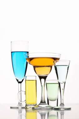 close up view of various alcohol cocktails in glasses on white backdrop clipart