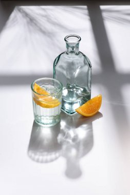 cam, limon parçaları ve şişe su ile bakış beyaz yüzey üzerinde kapatın