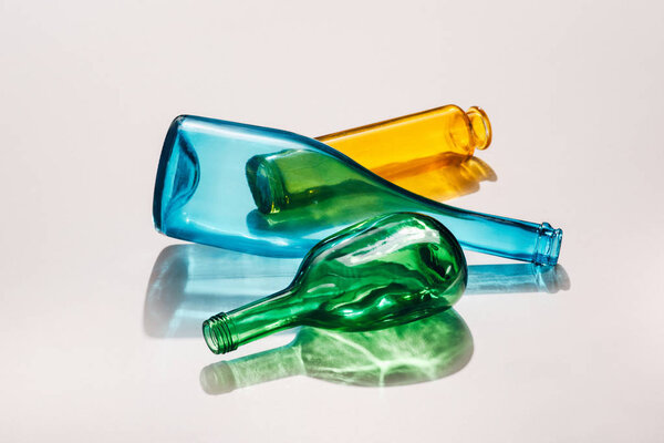 close up view of empty colorful bottles on white background