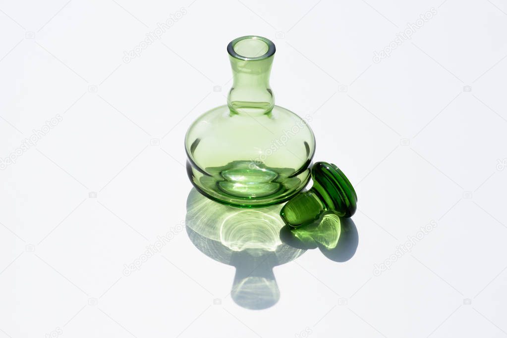 close up view of empty glass bottle and cork on white backdrop