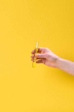 kırpılan atış izole sarı sıvı şişesi tutan kadın