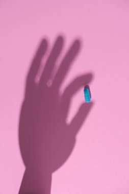 mavi hap pembe yüzeyde tutan el gölge Üstten Görünüm